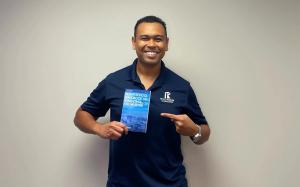 Tim Jedrek holds a book for flight school owners to grow their flight schools and boost enrollments