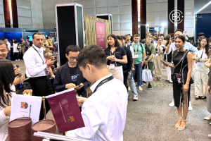 A group of iFX Expo Asia 2024 attendees queues at the EBC Financial Group booth.