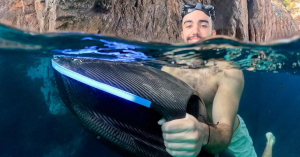 A swimmer using the SeaNXT Elite underwater scooter demonstrates its low buoyancy feature in clear waters.