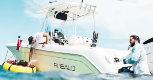 A boater prepares for a dive by placing Brownie’s SeaLiOn battery-powered tankless dive system into the water.