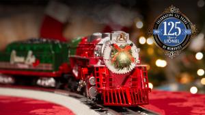 A Lionel model train decorated for Christmas rolls toward us down the track, with the new Lionel 125th anniversary logo in the top right corner.