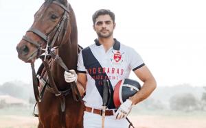 an Indian polo player stands with his horse