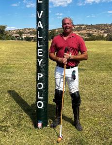 a polo player stands next to a goal post