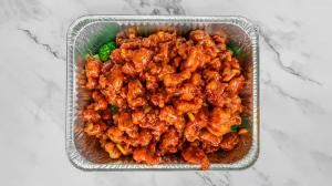 A half steam pan of General Tso's signature Orange Chicken, featuring crispy fried chicken tossed in a tangy, flavorful orange glaze—perfect for corporate catering and large gatherings