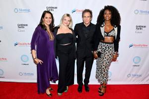 At the Equality Now 2024 gala S. Mona Sinha, Ella Stiller, Ben Stiller, and Beverley Knight stand together in a line to pose for a photograph against a wall with the Equality Now logo printed on it