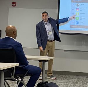 Ryan Abramson presenting to an audience using a powerpoint slide at a regional conference in Philadelphia, PA