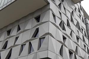 N-RG CLADDING RECOGNIZED IN USGLASS MAGAZINE’S ANNUAL DESIGN AWARDS FOR MALACHOWSKY HALL AT THE UNIVERSITY OF FLORIDA 3 Elevation view of Malachowsky Hall at the University of Florida, highlighting the dynamic shadows and undulating effect created by the volumetric design of aluminum panels.