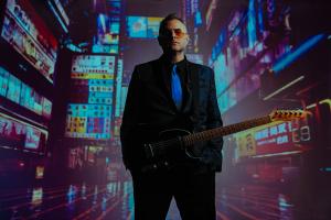 Daniel Corey holding his Fender Telecaster guitar against a cyberpunk background