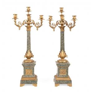 Pair of circa 1860 Napoleon III gilt bronze and gray-green porphyry four-light candelabra, each having scrolled acanthus form arms, drip pans, and nozzles on a tapering shaft (est. $4,000-$8,000).