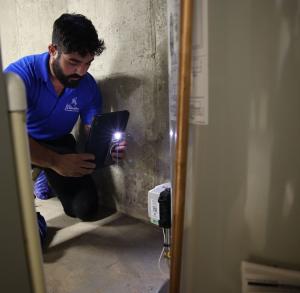 J. Blanton Plumbing technician performing a water heater repair, emphasizing the company’s expertise in emergency plumbing, water heater fixes, and installation services for the Holly & Hope 2024 event.