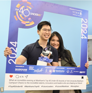 Top 40 Under 40 finalist Christopher Siu, awarded for Retail Revolutionaries, smiles with a friend, holding his plaque within a vibrant event frame celebrating young leaders and innovators.