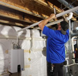 J. Blanton Plumbing technician installing a residential water heater, showcasing the company’s expertise in water heater installation and after-hours plumbing services for Chicagoland homeowners.