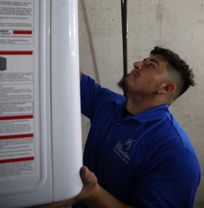 J. Blanton Plumbing technician conducting a water heater maintenance service, highlighting the importance of pre-holiday checks and the company’s expertise in plumbing contractors, water heater maintenance, and water heater repair.