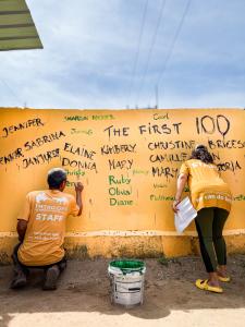 The Man That Rescues Dogs staff paint the names of 100 book readers onto the Sanctuary wall