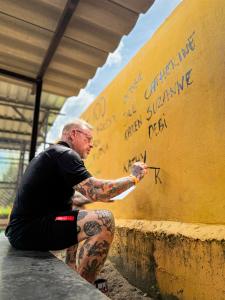 The Man That Rescues Dogs Founder Michael J. Baines paints the names of 100 book readers onto the Sanctuary wall