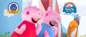 Two Peppa Pig characters wave to visitors at the Peppa Pig Theme Park Dallas/Fort Worth, featuring the Certified Autism Center™ (CAC) badge and park logo.