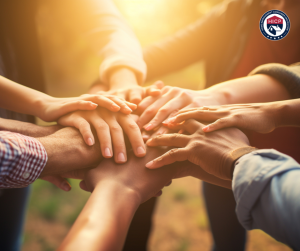 A close-up of diverse hands stacked on top of each other, symbolizing unity, collaboration, and the strength of a supportive community.