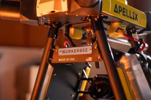 Close-up of the Apellix Power Wash System US1, focusing on the landing gear. The nameplate reads 'workerbee' with a small American flag next to it, highlighting the drone's identity and origin.