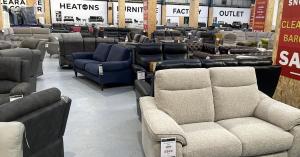 Image shows lots of sofas inside a warehouse