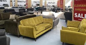 Image shows lots of sofas inside a warehouse