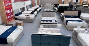 Image shows lots of beds inside a warehouse