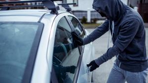 Burglar trying to break in by opening a locked car door.