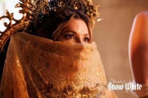 The Evil Queen hides her face with a beautiful gold lace scarf leaving only her beautiful eyes to been after a grotesque beauty practice