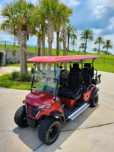 Red Off-Road Golf Cart with Palm Trees and Sunny Sky