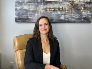 A portrait of Dr. Violet Klenov sitting in an office chair.