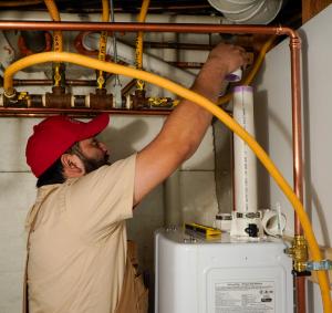 J. Blanton Plumbing technician installing a water heater, highlighting the company’s skills in water heater installation, maintenance, and Lincoln Park 24-hour plumbing services in support of Winterfest 2025.