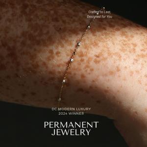 lose-up of a freckled wrist wearing a delicate 14k gold permanent bracelet with small bead accents, awarded the DC Modern Luxury 2024 Winner for Permanent Jewelry.”