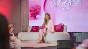 Adriana Gallardo sits on stage on a cream-colored couch.