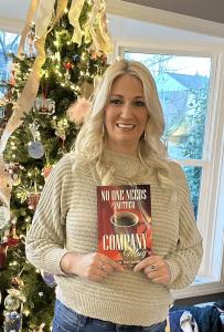 Author Lindsay Smith proudly displays her new book, No One Needs Another Company Mug: Stop Branding. Start Experiencing. Now available on Amazon.