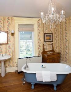 A crystal chandelier is above an antique clawfoot bathtub.