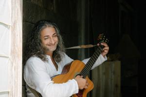 Shervin sitting with guitar