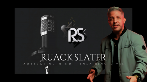 Ruack Slater, a motivational speaker and artist, stands in a studio with a microphone visible on the left and his stylized logo 'RS' in the background. Text at the bottom reads 'Ruack Slater - Motivating Minds - Inspiring Lives.'"