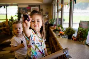 Preschooler raising marker while drawing at Preschool Powered by Play