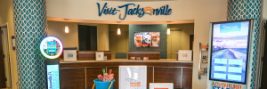 Brightly lit visitor center for Jacksonville, featuring brochures, digital displays, and a welcoming reception area.