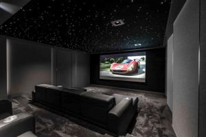 Custom home theater setup with projector, screen, custom seating and acoustics.