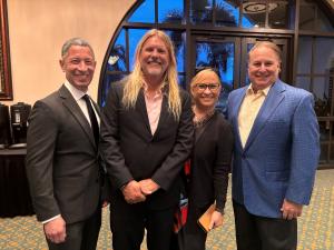 a group photo of 3 men and one woman standing up