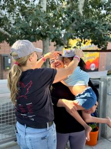 Team Select Home Care employee places a custom baseball cap on a medically complex pediatric patient at the San Francisco Giants spring training event.