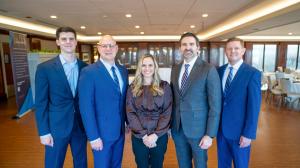 Several business professionals pose for a photo.