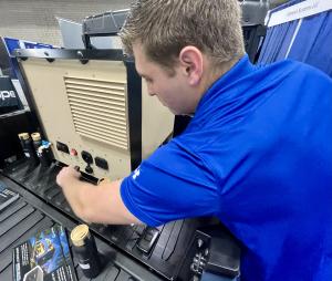 Courtesy of Genesis Systems: Zach Mixson demonstrates a small Polaris vehicle-mounted WaterCube at the 2025 Pacific Operational Science and Technology Conference in Hawaii. 
