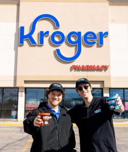 Photo of Protein Pints Co-Founders Michael Meadows & Paul Reiss standing outside of a Kroger store, each holding a Protein Pint ice cream