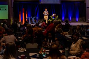 Photo of speaker and audience at True Charity Summit