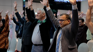 group of people raising their hands in the air symbolising awareness of blood health