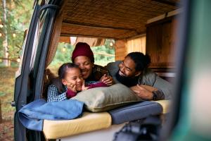 Family camping in the woods in the back of their car
