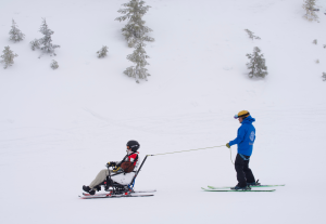 An instructor and adaptive athlete skiing on the mountain