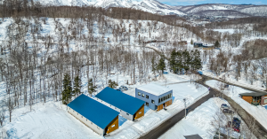 Aerial view of EdVenture Niseko and Les Elfes International’s activity center and student lodges, set in snowy Hokkaido with Hirafu Village in the distance.