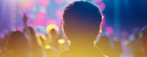Scene in a nightclub from the feature film DJ Ahmet with the main character silhouetted against bright, colorful lights